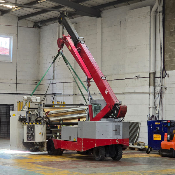 Two-piece sticker slitting machine being separated on active factory floor