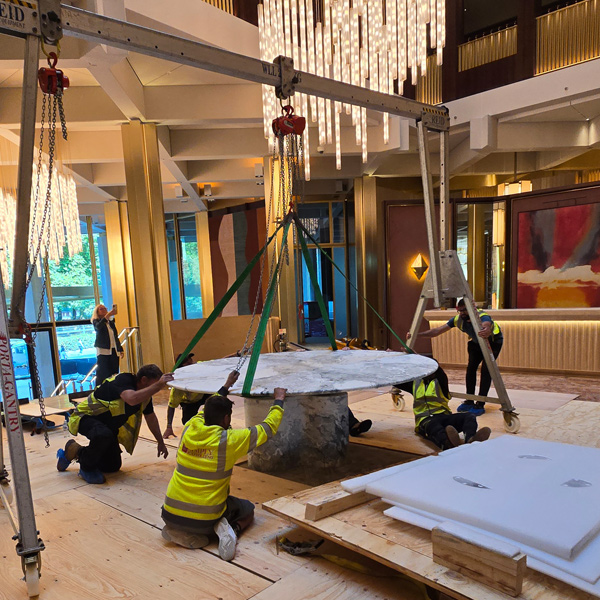 Manual handling team adjusting marble tables final position