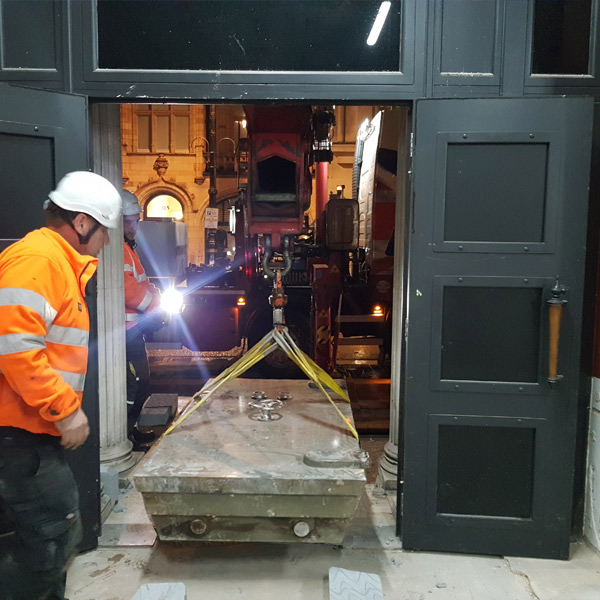 Heavy bank vault door being removed.