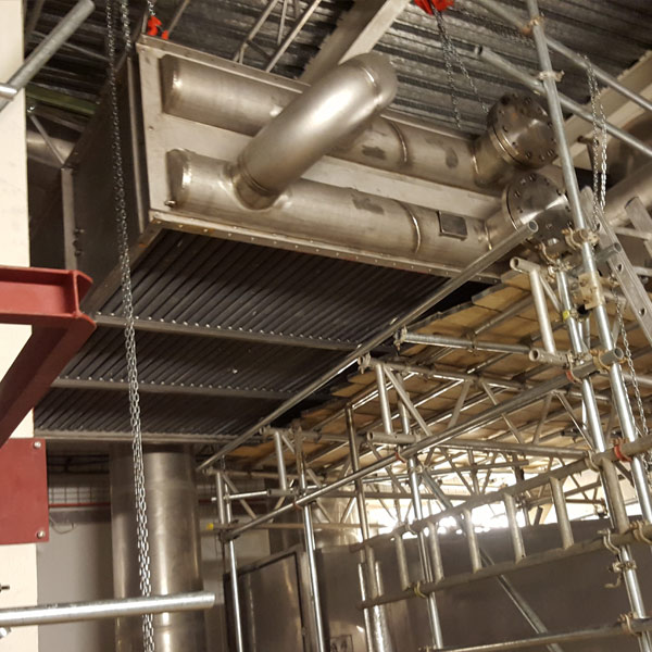 Heavy commercial boiler being moved using specialist equipment